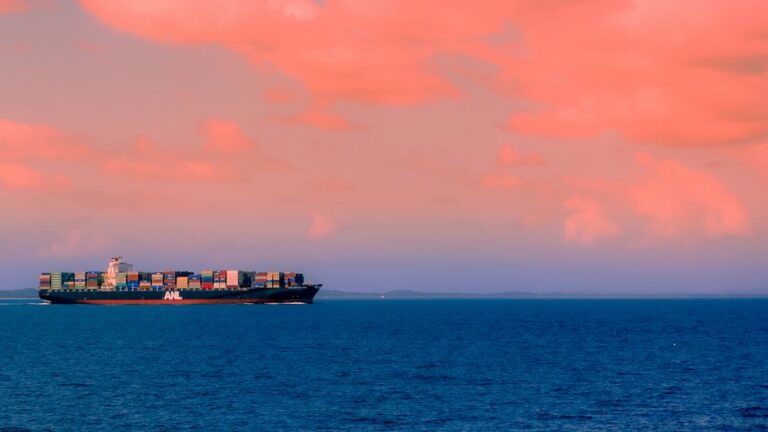 Cargo vessel at sea beneath clouds